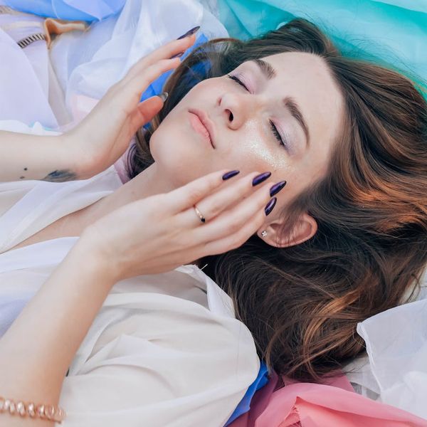 Close-up of a person's hands in a meditative pose with soft focus background.